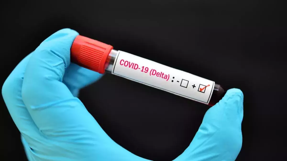 Eine Hand in Gummihandschuh hält eine positive Blutprobe mit Delta-Variante von COVID-19 