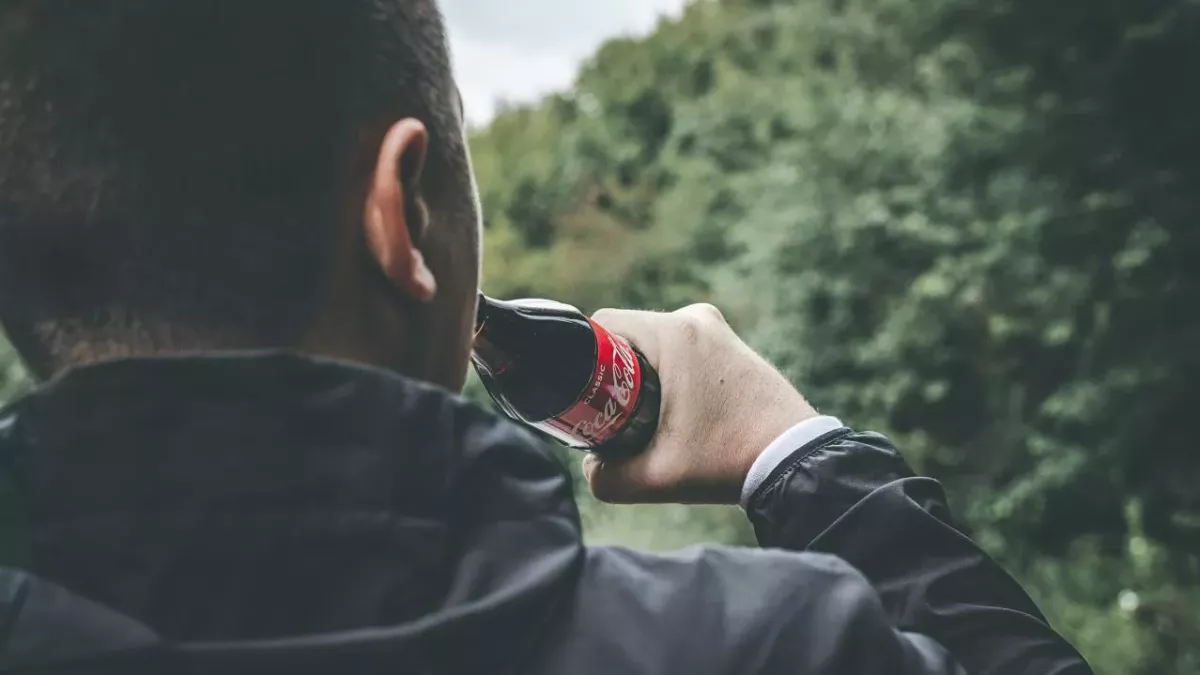 Mann trinkt zu viel Cola