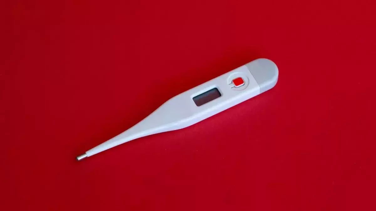 Ein Fieberthermometer auf rotem Hintergrund