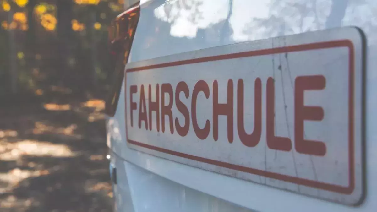 Ein Schild einer Fahrschule ist auf einem KFZ befestigt