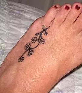 Tattoo einer Frau: Blumenranke auf dem Fuß