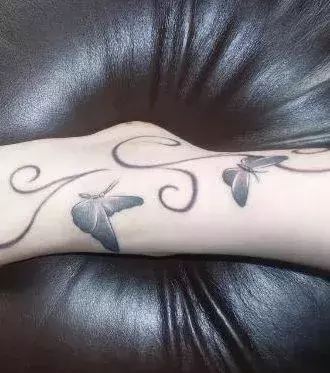 Tattoo einer Frau: Schmetterlinge auf dem Fuß