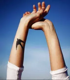 Tattoo für eine Frau: Schwalbe auf dem Unterarm