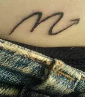 Tattoo für Frauen: Tattoo des Buchstaben M auf der Hüfte