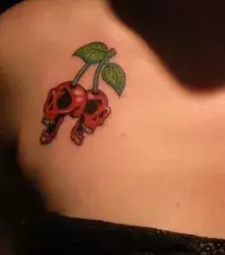Tattoos für Frauen: Kirsch Totenkopf Tattoo auf dem Arm einer Frau