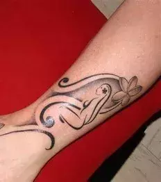 Tattoos für Frauen: Schwarz graues Tattoo auf der Wade einer Frau