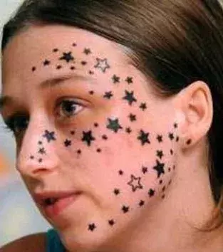 Tattoos für Frauen: Sterne Tattoo im Gesicht einer Frau
