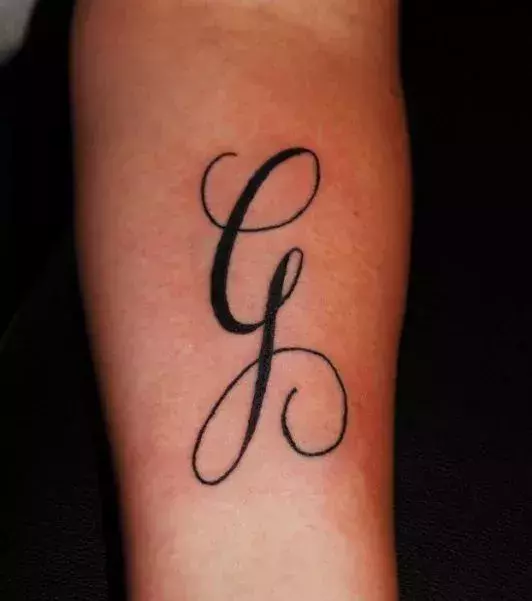 Tattoos für Frauen: Tattoo des Buchstaben G auf dem Unterarm einer Frau