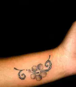Tattoos für Frauen: Tattoo einer Hawaiiblume auf dem Handgelenk einer Frau