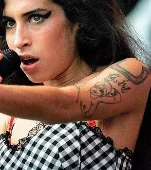 Tattoos für Frauen: Tattoo einer nackten Frau auf dem Oberarm von Amy Winehouse