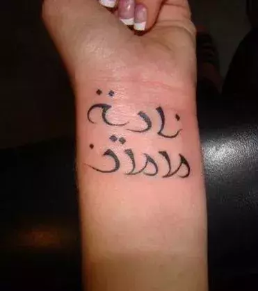 Tattoos für Frauen: Tattoo mit arabischen Schriftzeichen auf dem Handgelenk einer Frau