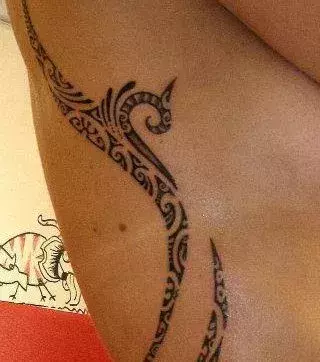 Tattoos für Frauen: Tribal Tattoo auf den Rippen
