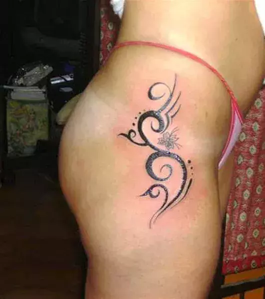Tattoos für Frauen: Tribal Tattoo auf der Hüfte einer Frau