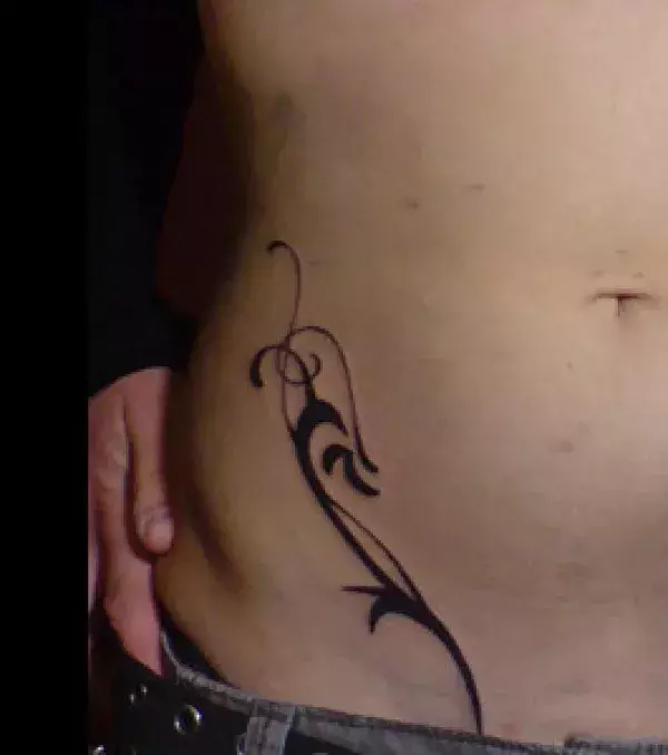 Tattoos für Frauen: Tribal Tattoo einer Frau auf dem Bauch