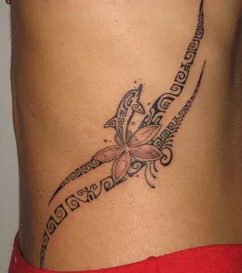 Tattoos für Frauen: Tribal Tattoo mit Delfin auf der Hüfte einer Frau