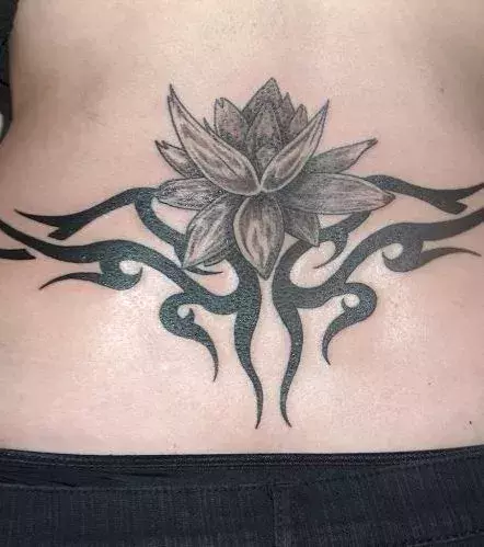 Tattoos für Frauen: Wird auch Arschgeweih genannt: Tribal Tattoo auf dem Steißbein einer Frau